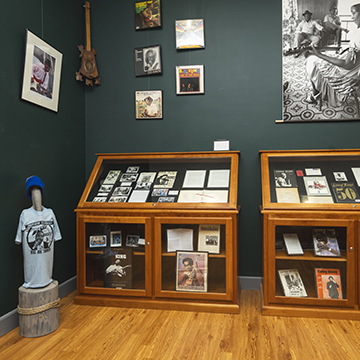 Two cases, photos, a t-shirt, and other items are shown for the 40th Anniversary of the Blues Archive at The J.D. Williams library in February 2025.