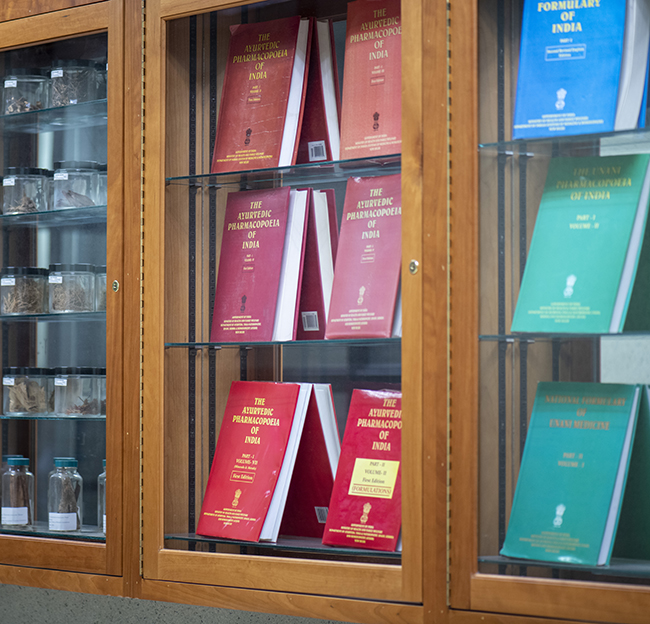 Pharmacy books displayed in a glass wall cabinet