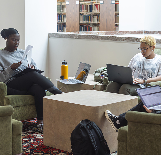 Three students study together in lounge chairs