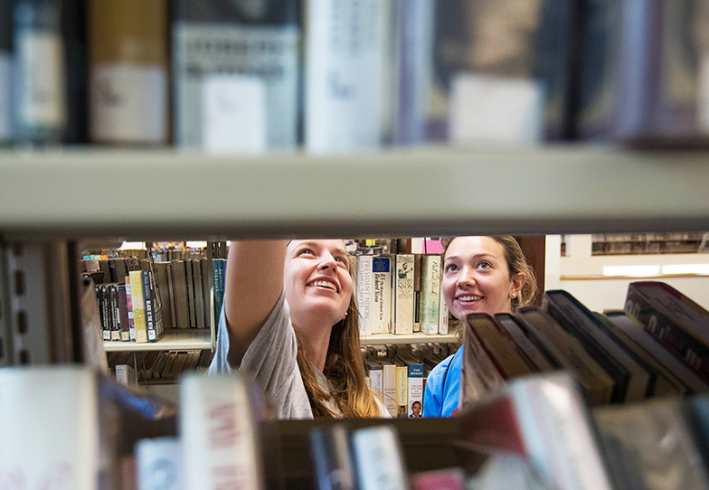 Students searching books in library