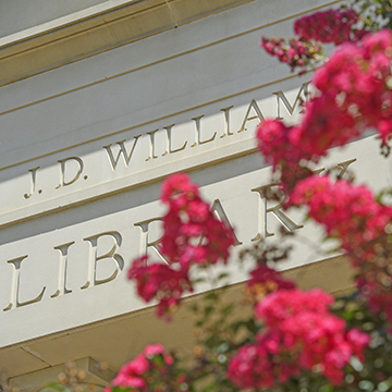 Close up of the engraving on J.D. Williams Library with pink flowers